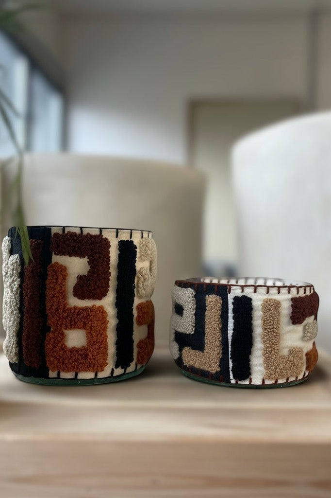 Atelier Marhaban Labyrinthe geurkaars in glazen pot met handgeweven textiel in beige, oranje en bruintinten.