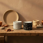 Atelier Marhaban Etnika geurkaarsen met Afrikaanse motieven in glas, omwikkeld met textiel. Verkrijgbaar in zwart en wit.
